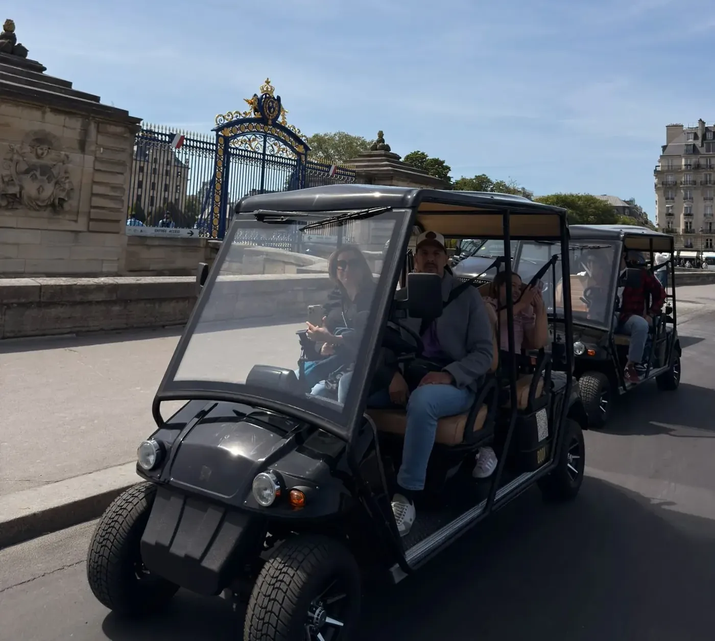 Golf carts passing the gilded gates on a private Paris tour
