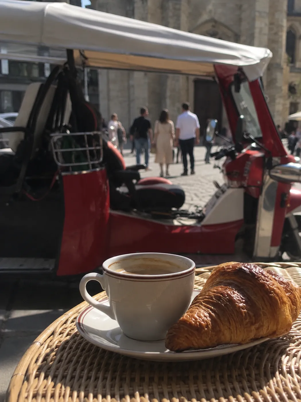 Coffee and croissant beside a Paris tuk-tuk